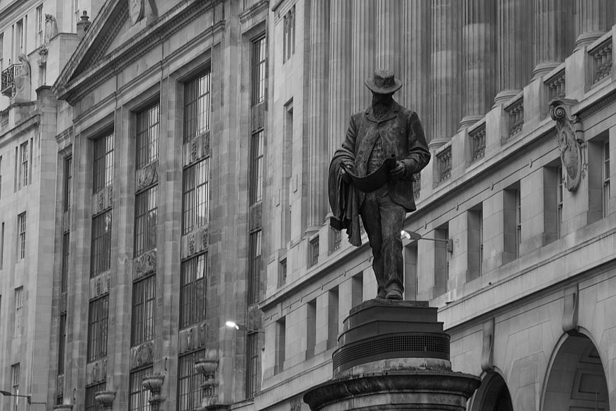Black and white statue of man in London city architecture