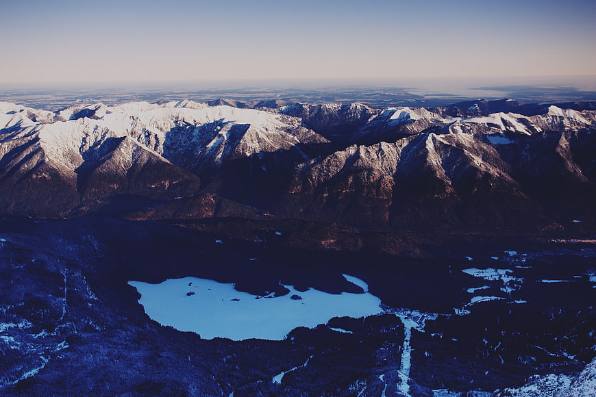 Aerial View of Snow-Capped Mountains and Frozen Lake