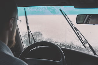 Man Driving Car in Heavy Rain with Wipers