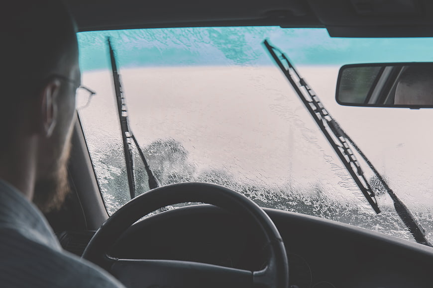 Man Driving Car in Heavy Rain with Wipers