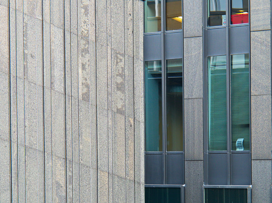 Modern building facade with stone cladding and glass windows