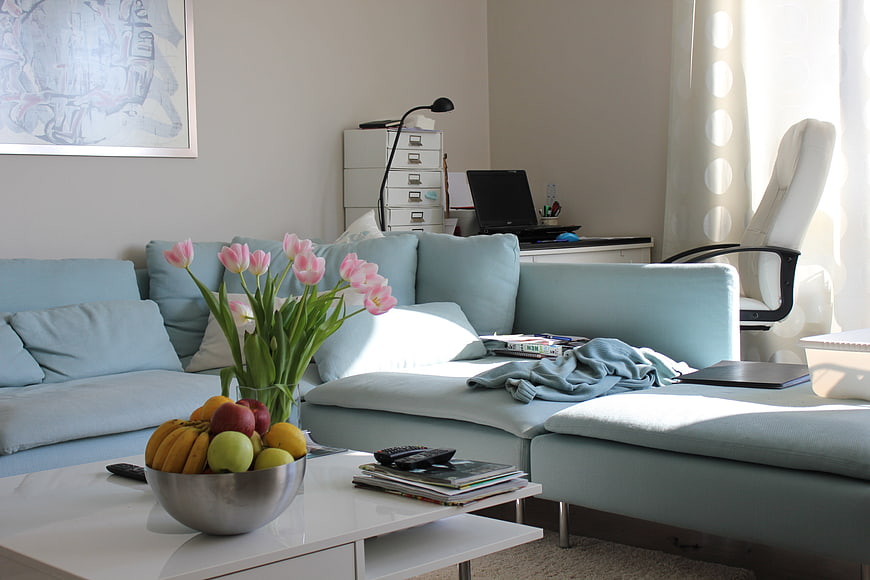 Modern Light Blue Living Room Interior With Tulips And Fruit Bowl