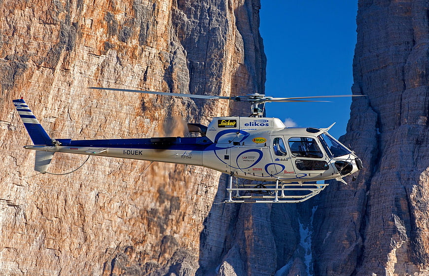 Helicopter flying near steep mountain cliffs