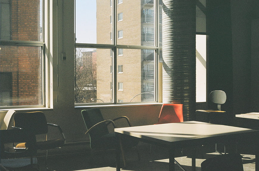 Sunlit modern office interior with table and chairs