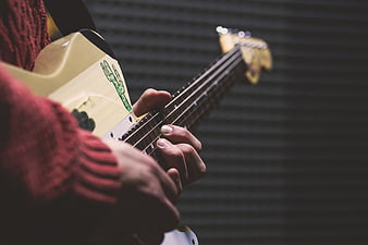 Close-up of hands playing a cream electric guitar