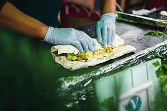 Hands in blue gloves preparing a fresh wrap