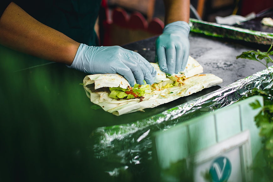 Hands in blue gloves preparing a fresh wrap