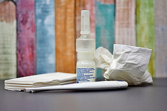 Nasal Spray Bottle With Crumpled Tissues And Thermometer On Table