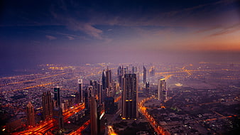 Aerial View of City Skyline at Dusk with Illuminated Skyscrapers