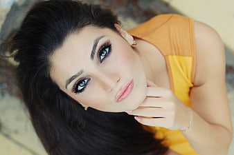 Close-up portrait of a woman with dark hair and makeup