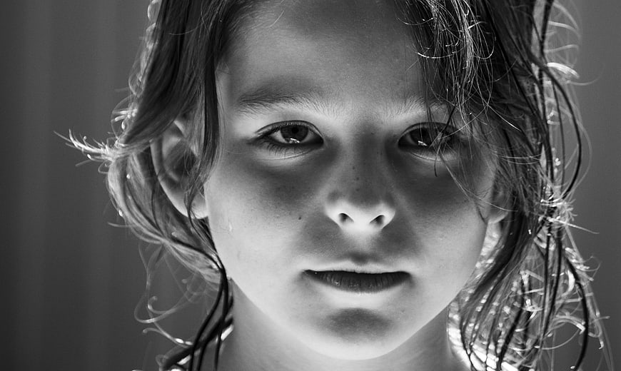 Close-up black and white portrait of a young girl with wet hair