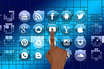 Hand Touching Social Media Icons on Blue Digital Grid