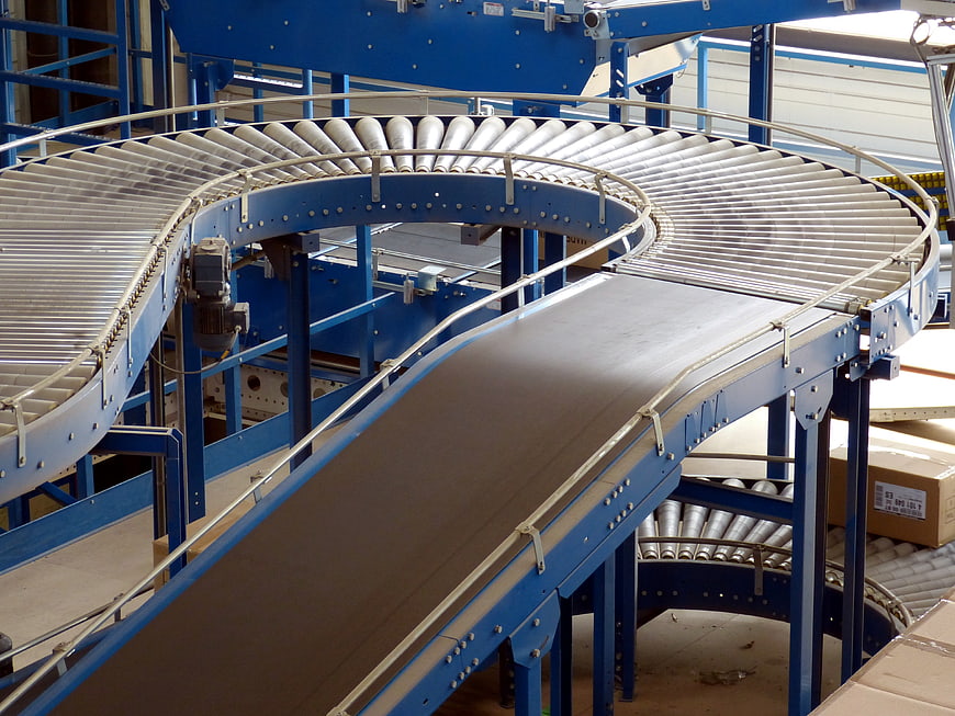 Curved industrial conveyor belt system in warehouse