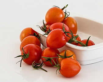 Fresh Red Tomatoes Spilling from White Ceramic Dish