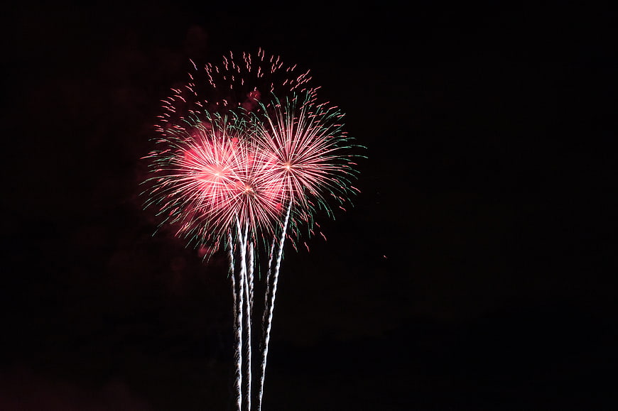 Red and green fireworks exploding in the night sky