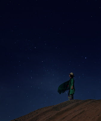 Woman in Green Standing Under Starry Night Sky