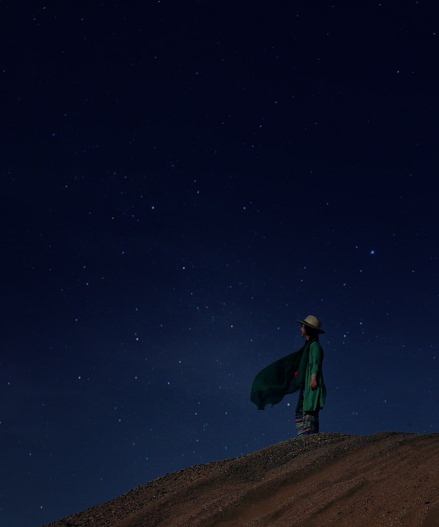 Woman in Green Standing Under Starry Night Sky