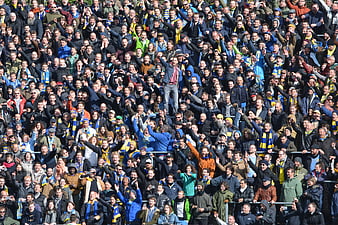 Excited football crowd cheering in stadium stands