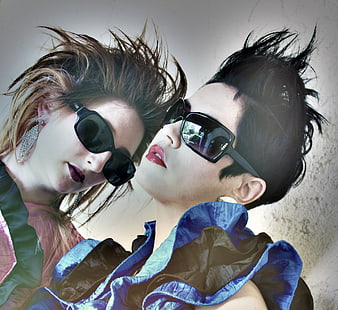 Two women in 80s retro fashion with spiky hair and sunglasses