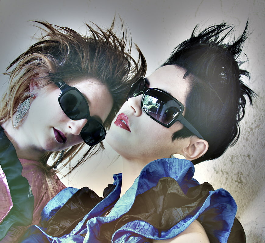 Two women in 80s retro fashion with spiky hair and sunglasses