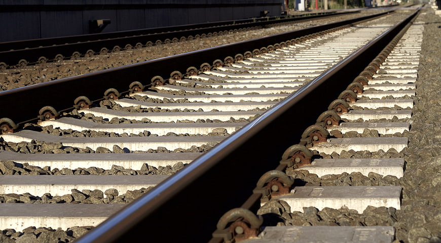 Low angle view of railway tracks with concrete sleepers and gravel