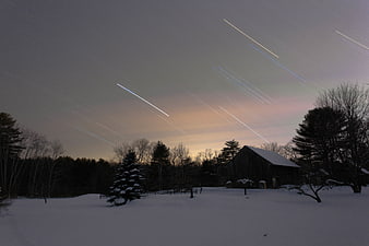 Winter Night Sky with Star Trails Over Snowy Barn