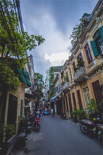 Narrow Street in Hoi An with Vintage Yellow Buildings and Scooters