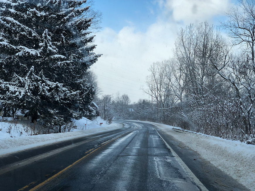 Snowy Winter Road Winding Through Forest Landscape