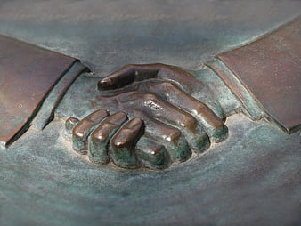 Close-up of bronze handshake sculpture symbolizing partnership