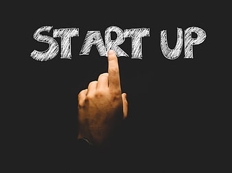 Hand pointing to START UP text on black background