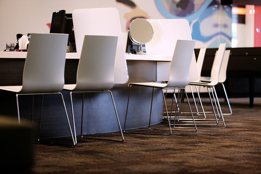 Modern beauty salon interior with white styling chairs and mirrors