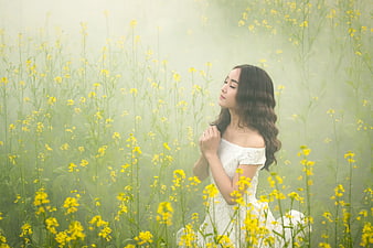 Woman in White Dress in Misty Yellow Flower Field