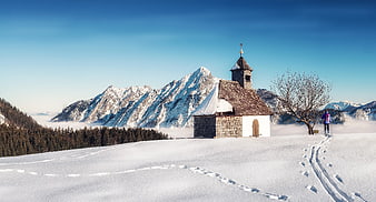 Snowy Mountain Chapel with Hiker and Blue Sky