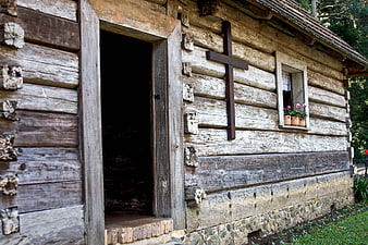 Rustic wooden chapel with cross and flower window