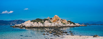 Panoramic view of rocky island in turquoise sea with blue sky