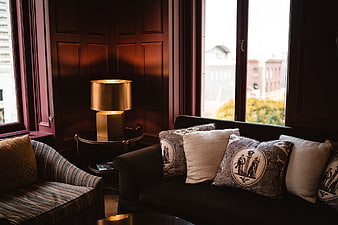 Luxurious dark interior with gold lamp and patterned pillows