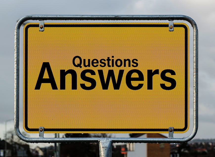 Yellow road sign reading Questions Answers on cloudy day