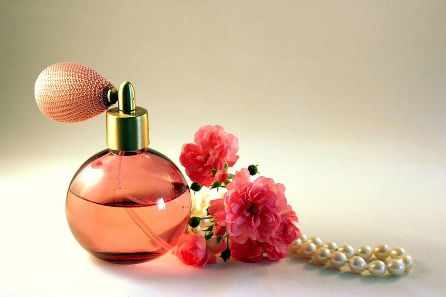 Vintage pink perfume bottle with roses and pearls