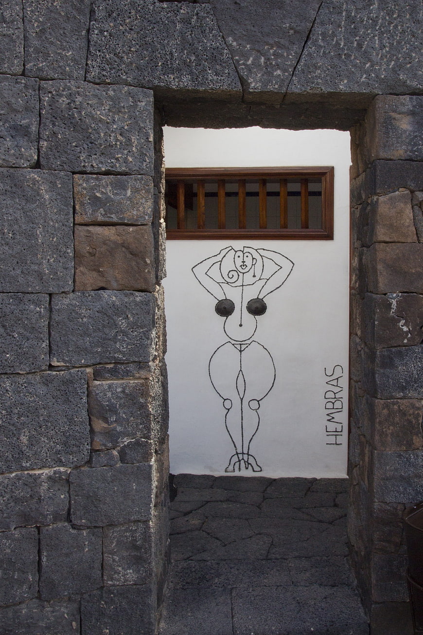 Ladies restroom entrance with stone archway and mural
