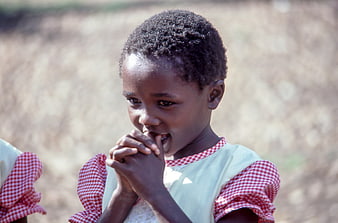 Close-up portrait of young African girl in red checkered dress