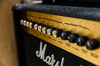 Close-up of a Marshall guitar amplifier control panel with gold knobs