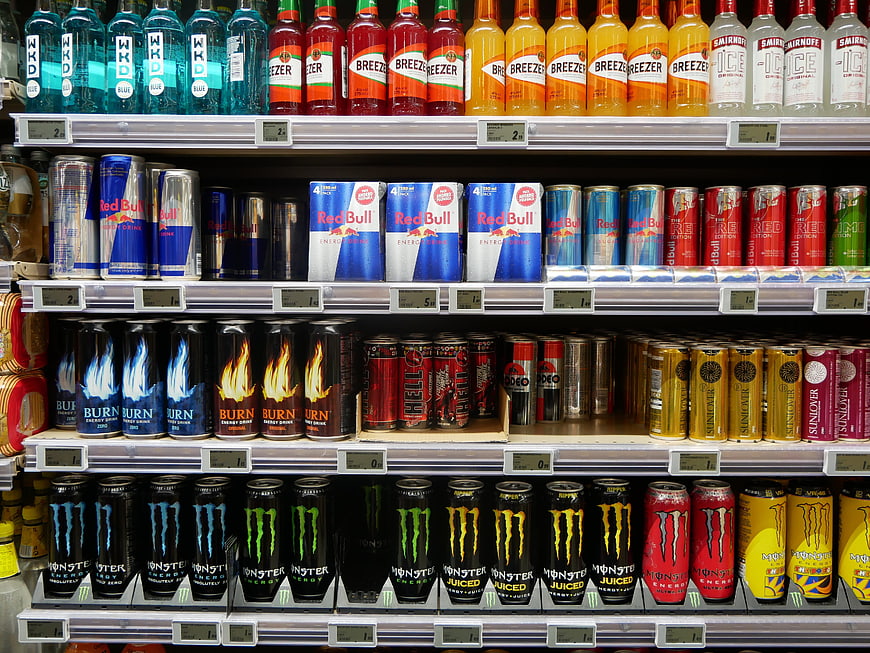 Supermarket shelf stocked with various energy drink brands and bottles
