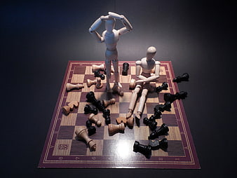 Wooden Mannequins on Chess Board Representing Frustration and Defeat