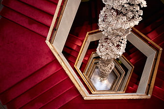 Abstract view of red spiral staircase with crystal chandelier