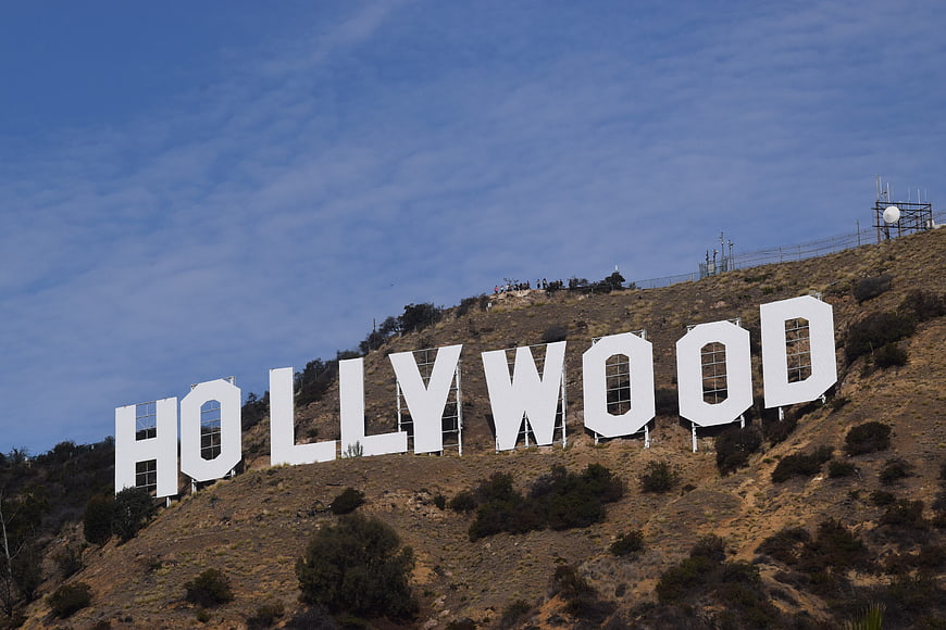 Hollywood Sign on Grassy Hillside Under Blue Sky