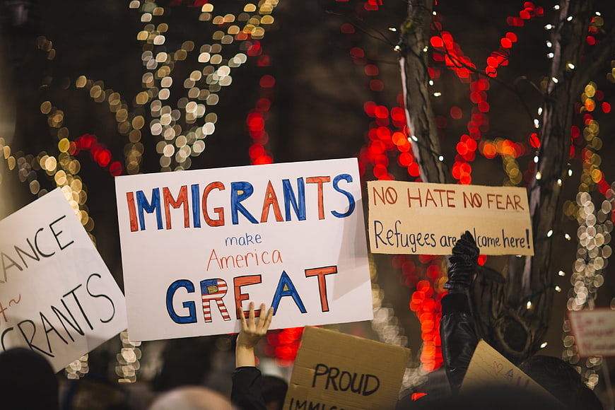 Protest signs supporting immigrants at night rally