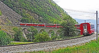 Red Mountain Train Crossing Stone Viaduct in Green Valley