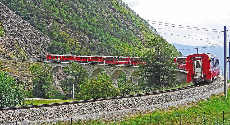 Red Mountain Train Crossing Stone Viaduct in Green Valley