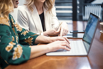 Two Women Collaborating on Laptop in Modern Office