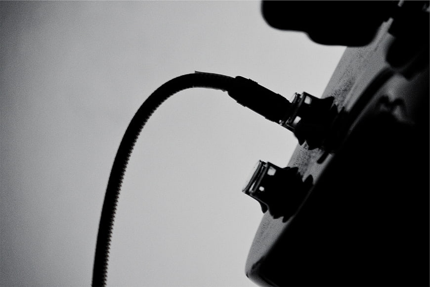 Black and white close-up of audio cable plugged into equipment
